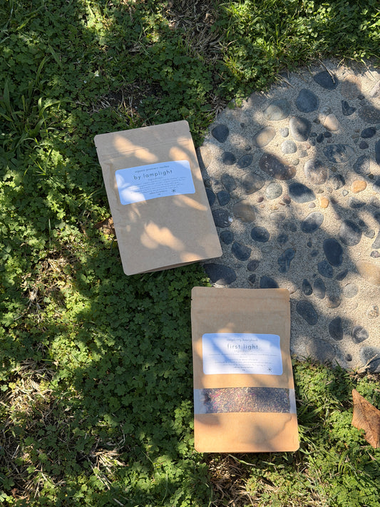 Two packages on grass with labels, one partially buried in sand.
