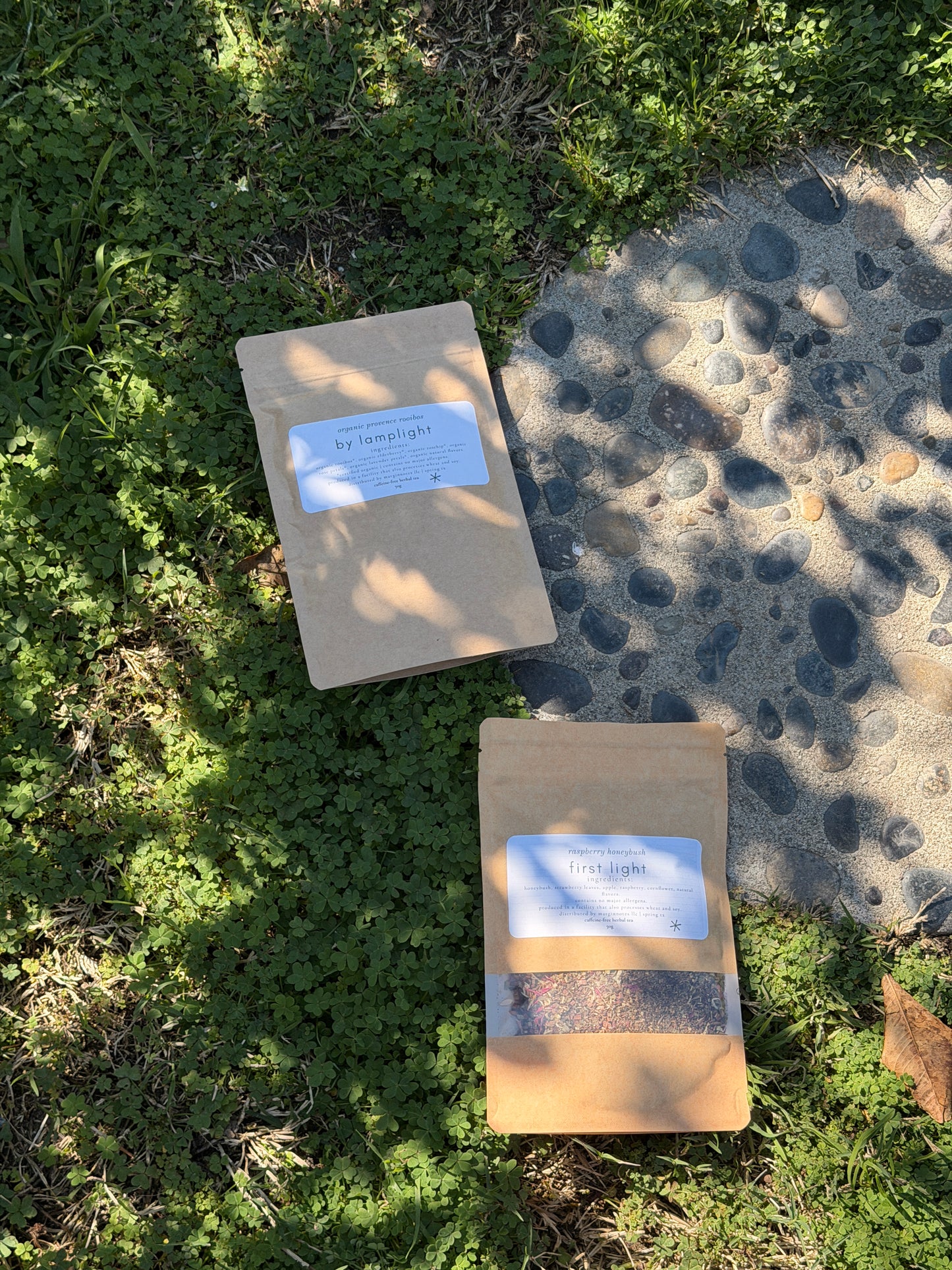 Two packages on grass with labels, one partially buried in sand.