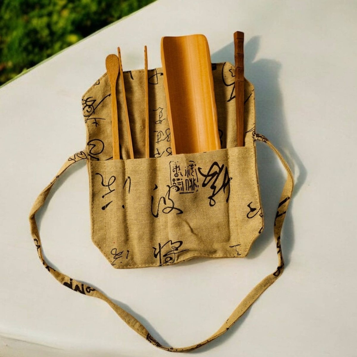 Bamboo Loose Tea Tool Set - marginnotesFabric bag with handles and a strap, containing loose leaf tea accessories on a white surface.